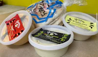 three bowls of hummus on a counter