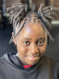 a young girl with dreadlocks in a hair salon