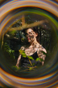 a woman is sitting in a circular hole in the woods