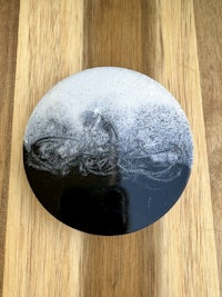 a black and white coaster on a wooden table
