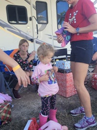 a little girl is standing in front of a rv