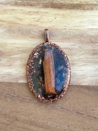 a copper pendant with a stone in it