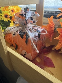 a wooden box filled with flowers and pumpkins