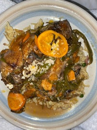 a plate with chicken, rice and orange slices