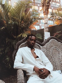a man sitting on a wicker chair