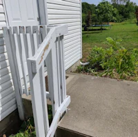 a white fence with a white gate in front of a house