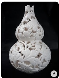 a white vase with intricate carvings on it