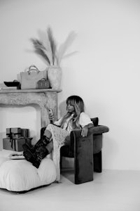 a black and white photo of a woman sitting in a chair