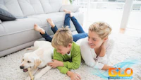 a woman and a child laying on the floor with a dog