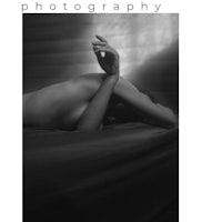 a black and white photo of a woman laying on a bed