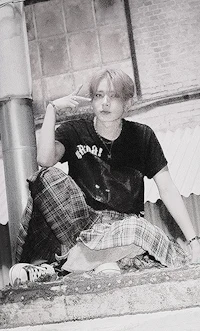 a black and white photo of a man in a plaid skirt