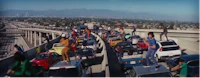 a group of people standing on top of cars on a highway