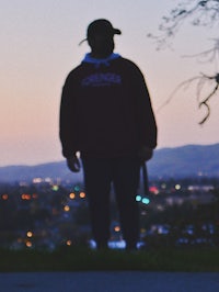 a man standing on a skateboard at dusk