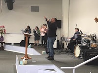 a man singing in front of a group of people