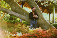 a woman leaning against a tree