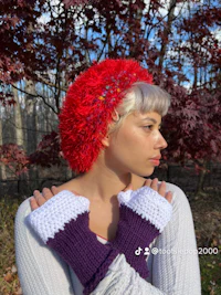 a woman wearing a red hat and purple gloves