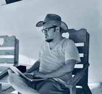 a man in a cowboy hat using a laptop
