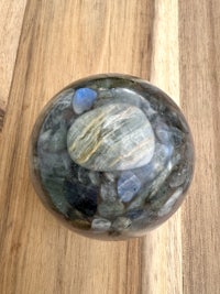 labradorite sphere on a wooden table