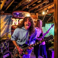 a group of people playing guitar in a barn