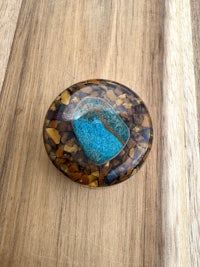 a blue and brown stone ring on a wooden table