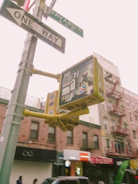 a one way street sign on a pole in a city