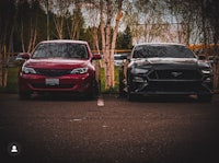 two cars parked next to each other in a parking lot