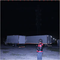 a man standing in front of a truck at night