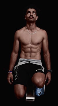 a shirtless man posing on a black background