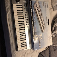an electronic keyboard sitting on top of a bed
