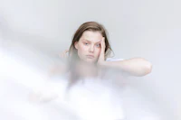 a young woman with her hand on her face