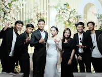 a group of people posing for a photo at a wedding