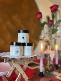 three jars of body butter sitting on a wooden table
