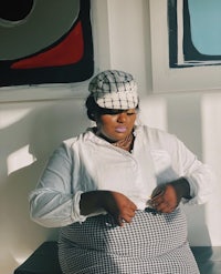 a woman wearing a hat and a checkered skirt