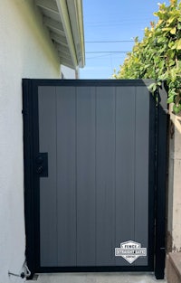 a gray gate with a black door