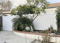 a backyard with a white fence and plants