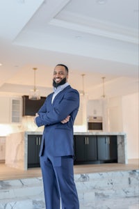 a man in a suit standing in front of a marble floor