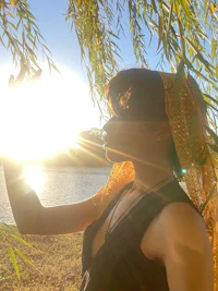a woman wearing a yellow scarf in front of a tree