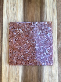 a piece of pink salt on top of a wooden cutting board