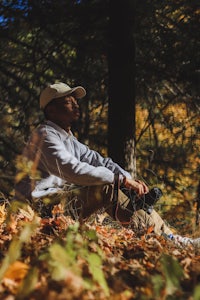 a man sitting in the woods with a camera