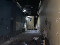 an abandoned hallway with graffiti on the walls