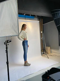 a woman standing in front of a camera in a studio