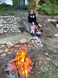 a group of people sitting around a campfire