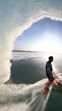 a man is riding a surfboard through a tunnel