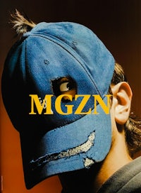 a man wearing a blue cap with the word mgzn on it