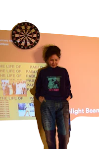 a woman standing in front of a dart board