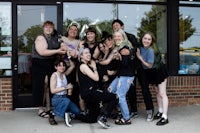 a group of people posing in front of a store