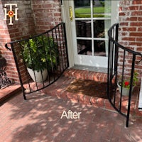 a front porch with wrought iron railings and potted plants