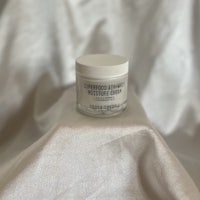 a jar of cream sitting on top of a white cloth