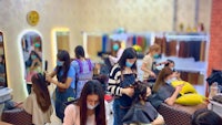a group of people in a hair salon with masks on