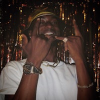 a man wearing a hat and a gold ring